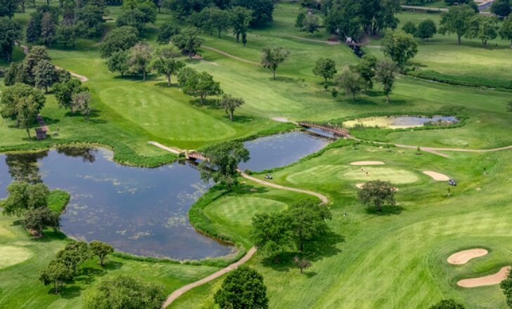 Aerial view of a golf course with ponds and sand traps in Golden Valley, next to The Winn at Golden Valley apartments