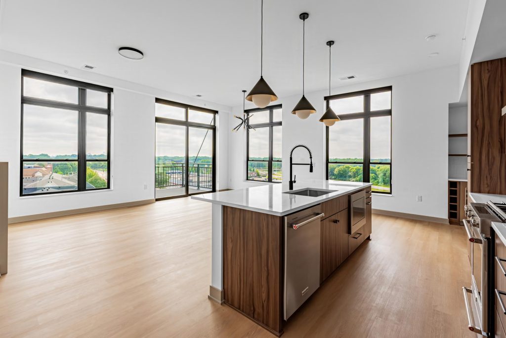 Kitchen island with quartz countertop and pendant lights in bright open space