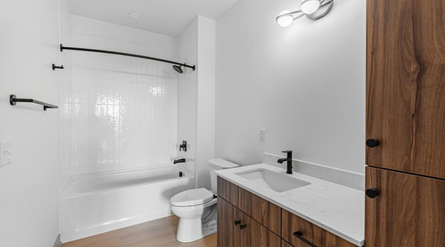 Modern bathroom at The Winn at Golden Valley with bathtub and wood cabinetry
