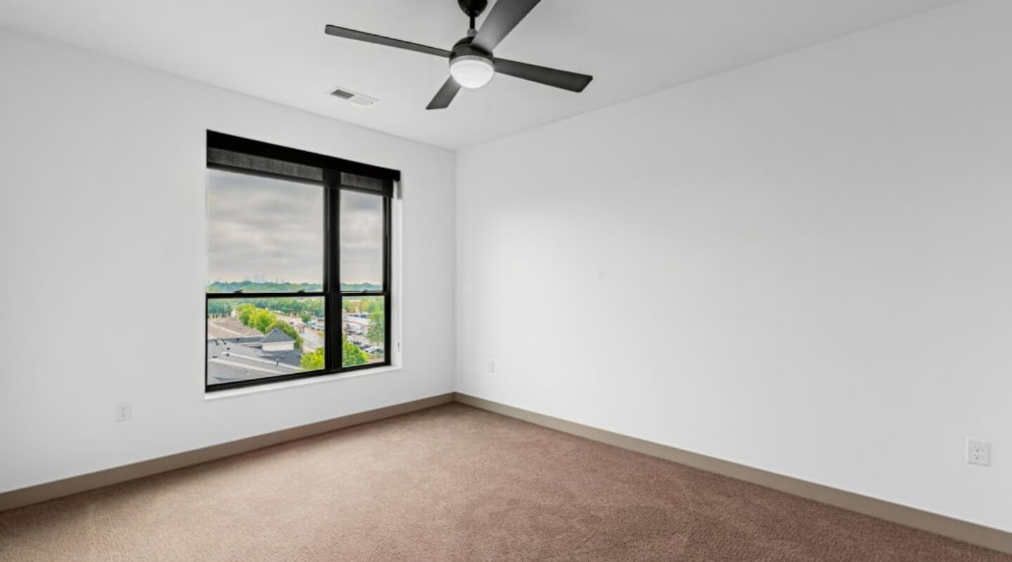 Bedroom at The Winn at Golden Valley with large window overlooking the city