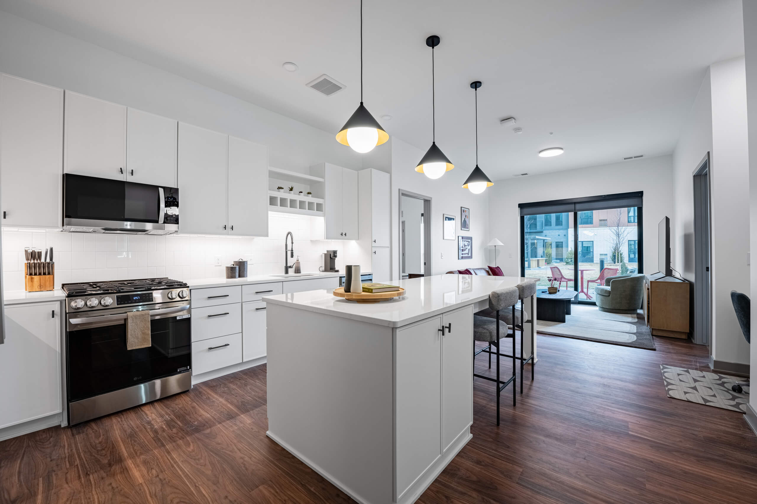 Apartment living and dining area with open floor plan, large windows, balcony view, and modern furnishings