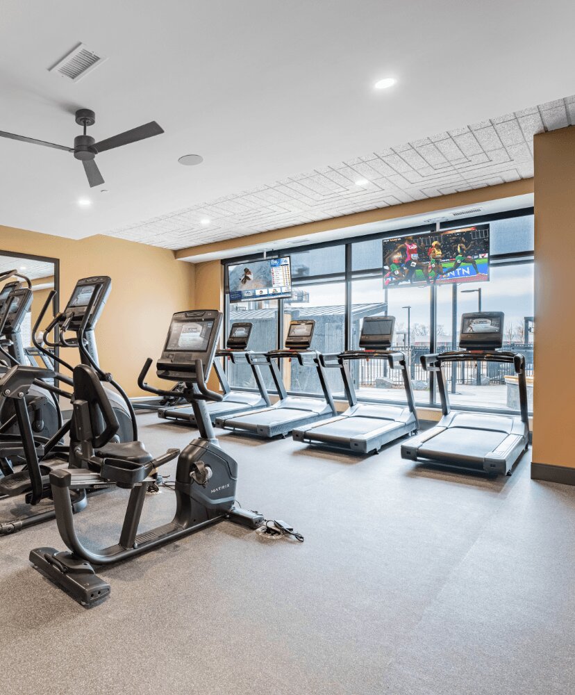 fitness room with large windows and treadmills.